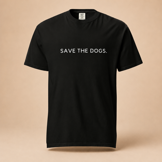 Woman in oversized garment-dyed black Mission Tee with Save the Dogs text, styled with cream trousers in a warm-toned studio